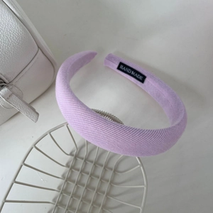 Gros plan du serre-tête rose à carreaux avec étiquette hand made et dents antidérapantes