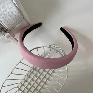 Détail d'un serre-tête rose à carreaux épais en cuir synthétique avec doublure noire