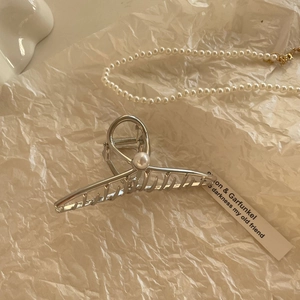 Silver geometric hair claw clip with pearl accent on elegant textured background
