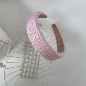 Détail du serre-tête rose montrant la texture du tissu gaufré et la doublure antidérapante