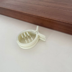 Dettaglio macro del fermaglio in acrilico beige con denti intrecciati per capelli