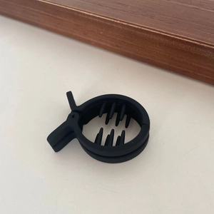 Dettaglio ravvicinato di una pinza per capelli nera opaca con denti antiscivolo interni