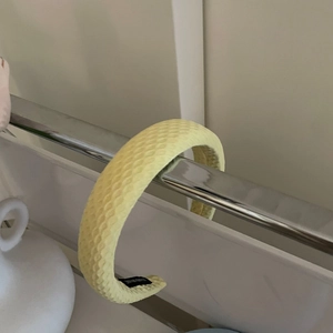 Detail of creamy waffle texture fabric headband with hand made label on a metal rack