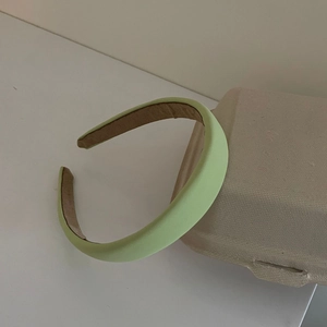 Diadema acolchada verde pistacho de esponja con acabado de tela y diseño minimalista