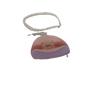 Purple acetate hair claw clip and white pearl hair tie accessory set on plain background