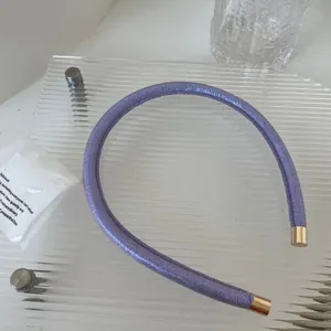 Détail du serre-tête violet avec texture granulée et embouts élégants en métal doré