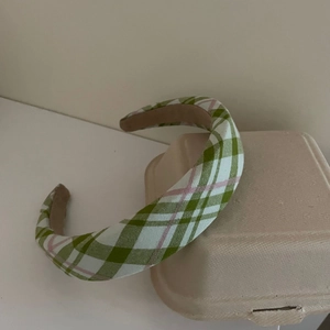 Detalle de diadema de esponja a cuadros verdes y blancos mostrando la textura de la tela tejida