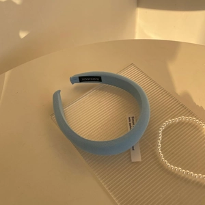 Detail of light blue padded sponge headband with fine twill fabric and handmade label