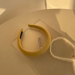 Detail of yellow padded sponge headband with handmade label and twill fabric texture