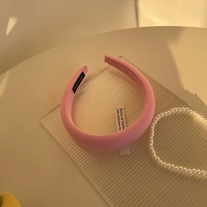 Detail of pink ribbed fabric headband showing handmade woven label and soft texture