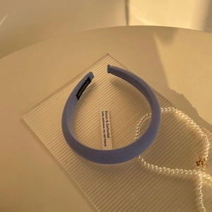 Detail of light blue twill sponge headband showing the handmade label and knit texture