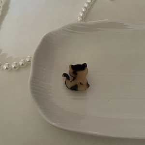 Primer plano de una pinza para el pelo de gato en carey sobre un plato decorativo