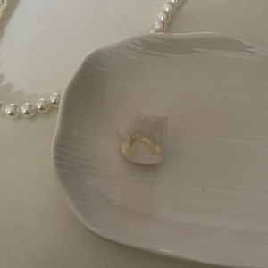 Primer plano de una pinza para el pelo de gato en acetato blanco perlado sobre bandeja