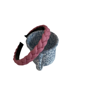 Braided pink macaron headband with thick sponge padding on a ceramic cup background
