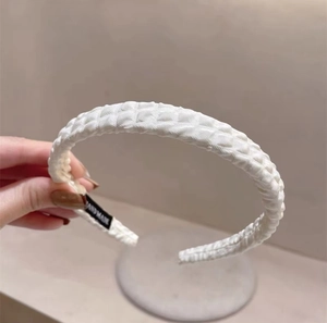 White fabric headband with woven geometric texture and handmade inner label for women