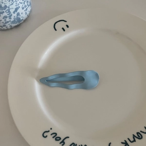 Matte hellblaue wellige Haarklammer für Damen auf einer Keramikschale präsentiert