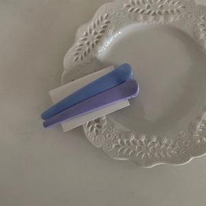 Nahaufnahme von mattem Harz Haarklammern-Set in Marineblau und Lila auf weißer Karte