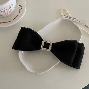 French style double-layer black bow hair clip with square rhinestone on a textured white plate