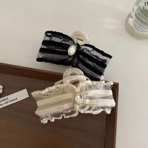 Bow hair claw clips with mesh lace and crystal embellishments on wooden tray