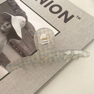French retro blue and white checkered acetate hair claw clip on a fashion magazine