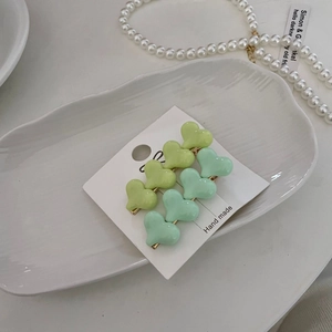 Set of two heart-shaped gradient hair clips in lime and mint green on a display card