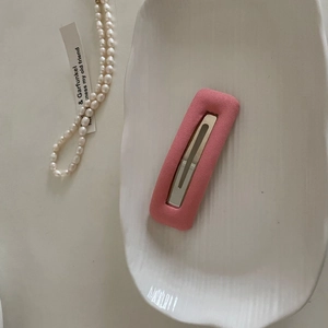 Pastel pink matte sponge hair clip for women with rectangle hollow design on ceramic plate