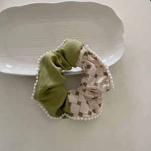 French green and beige checkered scrunchie with white pearl trim on a white plate