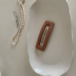 Detail view of matte Morandi pink rectangle sponge BB hair clip on a ceramic tray