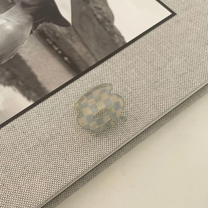 Detail of blue and beige checkered acetate hair claw clip with metal spring mechanism
