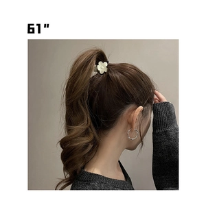 Gros plan d'une pince à cheveux fleur mate et de boucles d'oreilles créoles argentées
