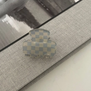 Detailed view of large acetate hair claw with blue and white checkerboard pattern texture