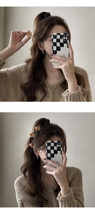Gros plan de mini pinces à cheveux fleurs mates aux tons marron sur un pull en maille