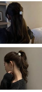 Détail d'une mini pince à cheveux fleur blanche fixant une queue de cheval et une demi-queue