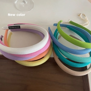 Cerchietti per capelli in spugna a righe color macaron su un vassoio di legno