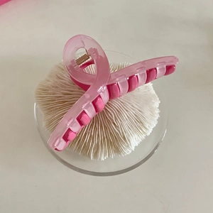 Detail of a dual-tone pink French INS style macaron hair claw clip with cutout design