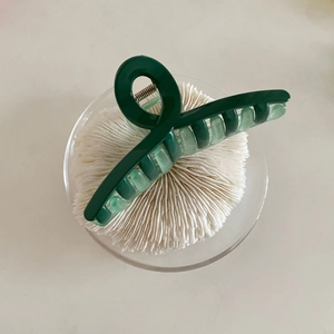 Detailed close-up of a large dark green French style hair claw clip with glossy finish