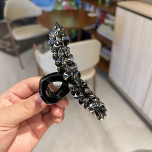 Elegant large shark hair claw with dark grey rhinestones on a glossy black finish