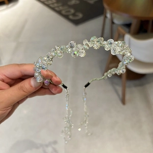 Detail of crystal beaded headband with shimmering detachable tassels and light green silk wrap