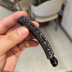 Barrette banane ornée de strass brillants et de perles dorées au fini noir chic