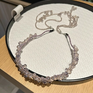 Close-up of handmade crystal headband with purple faceted beads and elegant fringe chain