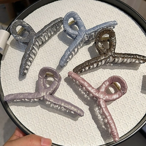 Detailed set of five metallic fabric shark hair claws in pastel and neutral tones