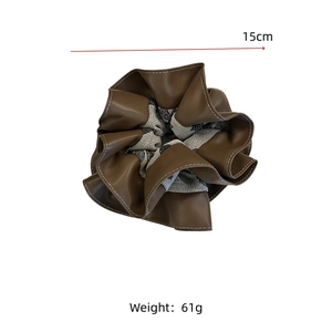 Detail view of 15cm large brown leather and gray fabric scrunchie with layered texture
