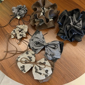 Close-up of premium faux leather pleated scrunchies with elegant jacquard bow hair clips