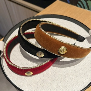 Detailed view of vintage velvet headbands with gold embroidery and embossed metal emblem