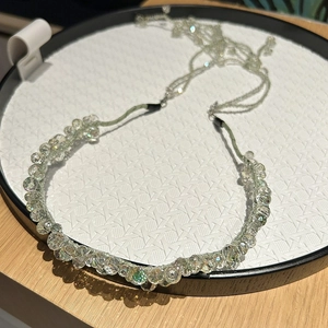 Detail of beaded crystal headband with luxury detachable fringe and light green woven base