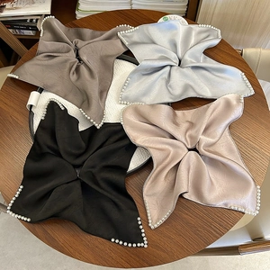 Vue détaillée de quatre foulards en satin avec bordures perlées en couleurs neutres