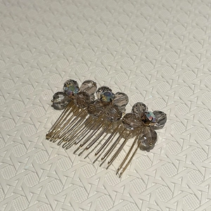 Detailed close-up of crystal sun-flower hair comb with grey beads and gold metal teeth
