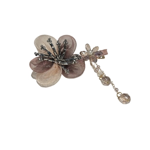 Pince à cheveux fleur en organza avec perles de cristal et glands sur fond blanc