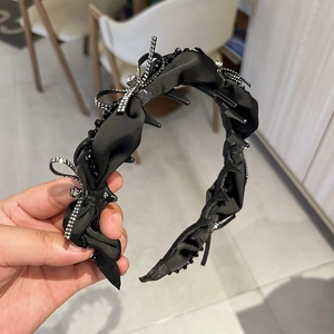 Detail of elegant black velvet headband with rhinestone bow design and non-slip inner teeth