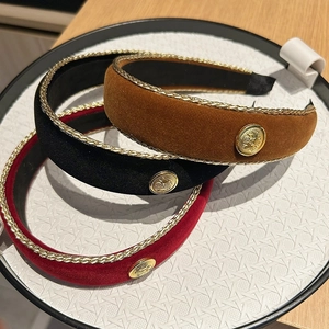 Detailed macro view of vintage velvet headbands in burgundy, black, and brown with gold trim